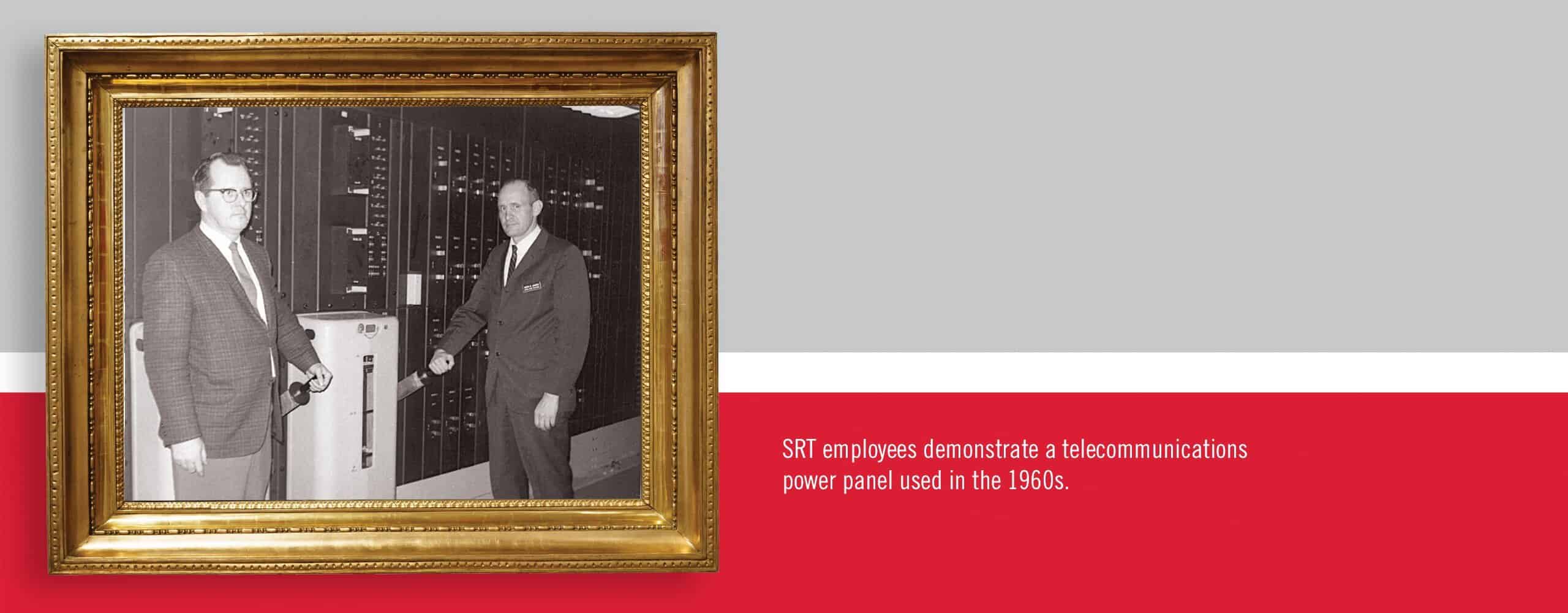 SRT employees demonstrate a telecommunications power panel used in the 1960s.